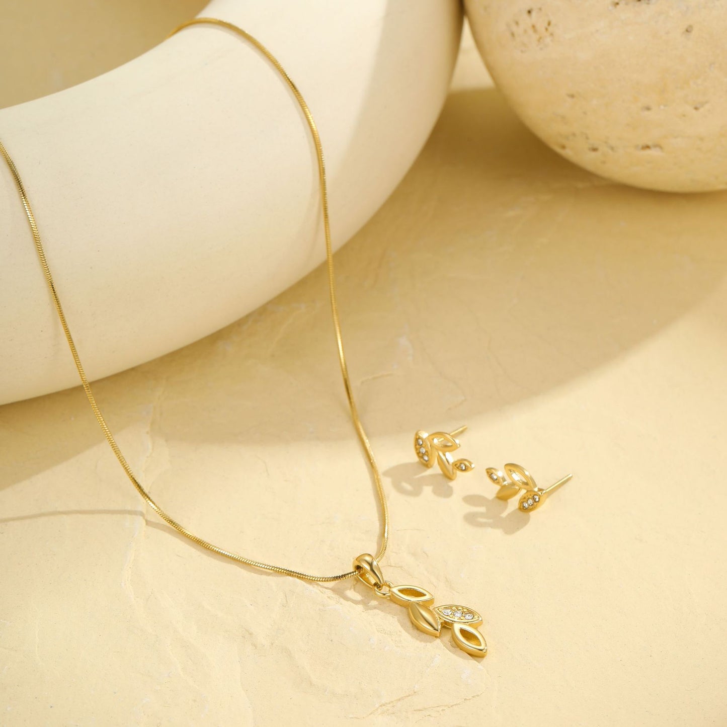 Collar con dije de hoja floral minimalista y aretes de acero inoxidable con incrustaciones de diamantes de imitación y acabado chapado