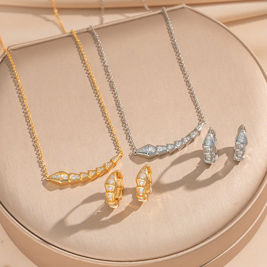 Set collana e orecchini in acciaio al titanio con forma a serpente minimalistica da donna con intarsio in strass e placcatura in oro