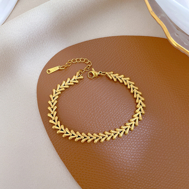 Bracciale da donna minimalista a V in acciaio al titanio con intarsio color oro e trama ondulata