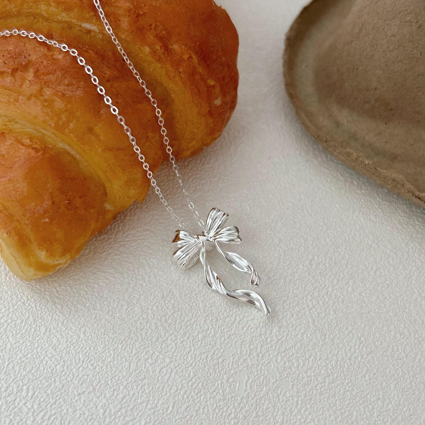 Minimalist Bow-Shaped Pendant Necklace in Sterling Silver with Gold Plating on Cross Chain