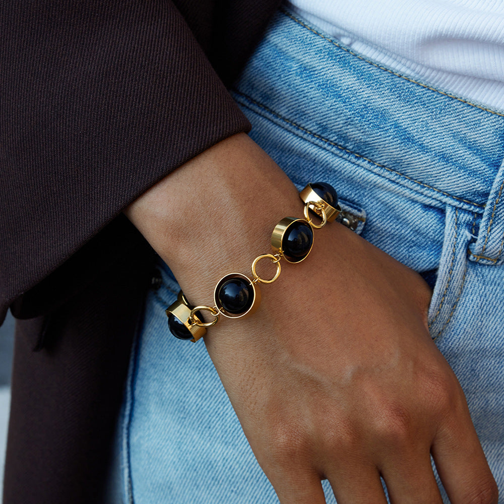 Bracciale minimalista geometrico girevole con chiusura a T in perline di vetro nero e acciaio al titanio con finitura placcata