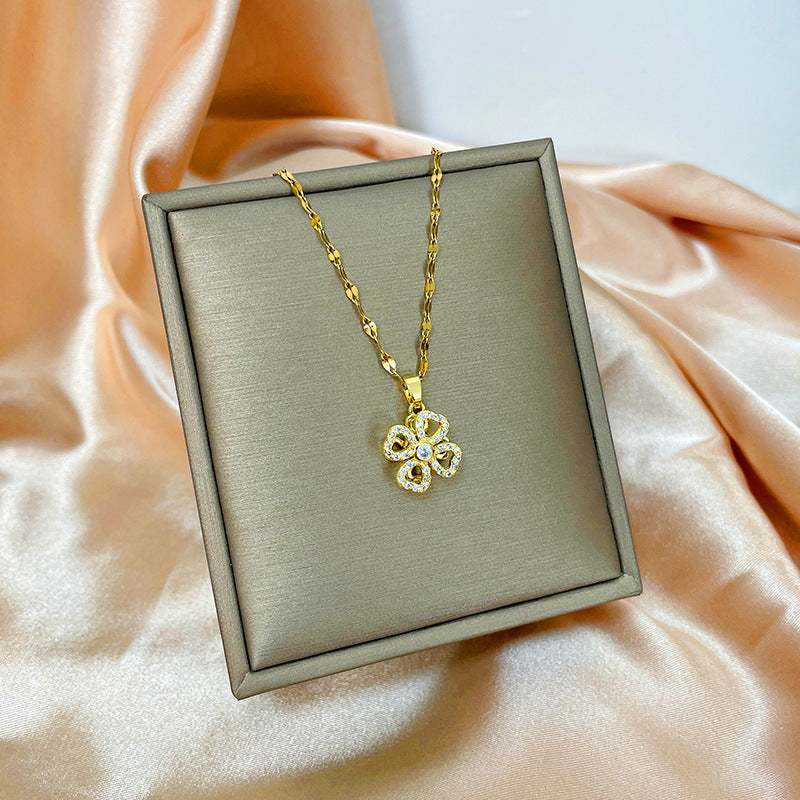 Collana con ciondolo girevole a quadrifoglio in acciaio al titanio con zirconi micropavé da donna