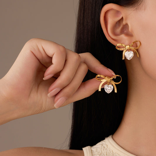 Pendientes minimalistas de lazo con corazón y diamantes de imitación de acero de titanio para mujer, para uso en verano, joyería de moda resistente a la decoloración