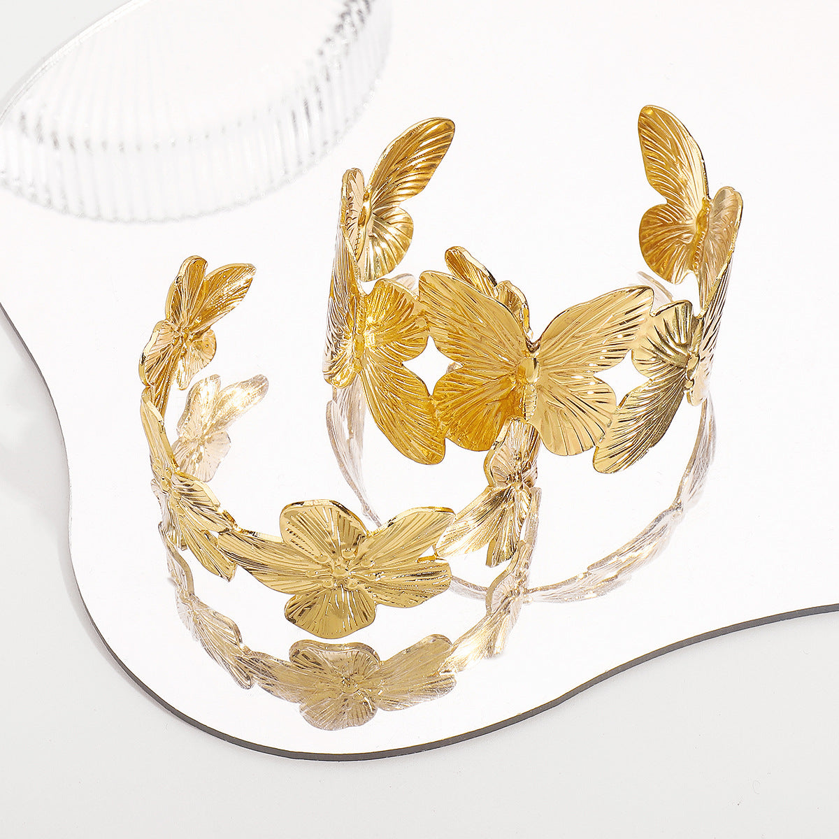 Pulsera de aro minimalista con mariposa y flores en tonos fríos con acabado de hierro galvanizado