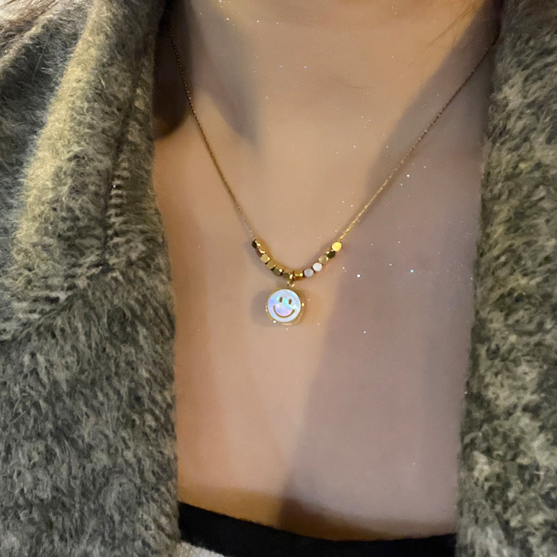 Collana con pendente a faccina sorridente minimalista da donna in acciaio al titanio con intarsio in madreperla e finitura placcata