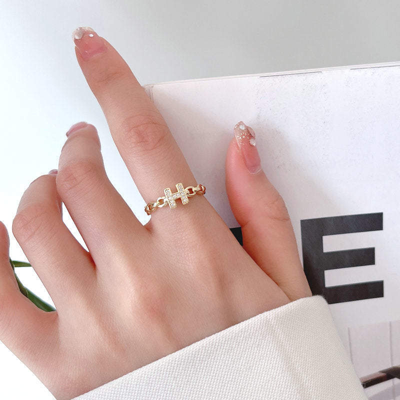 Anello minimalista con lettera H in ottone placcato oro con dettagli in strass e fascia aperta regolabile