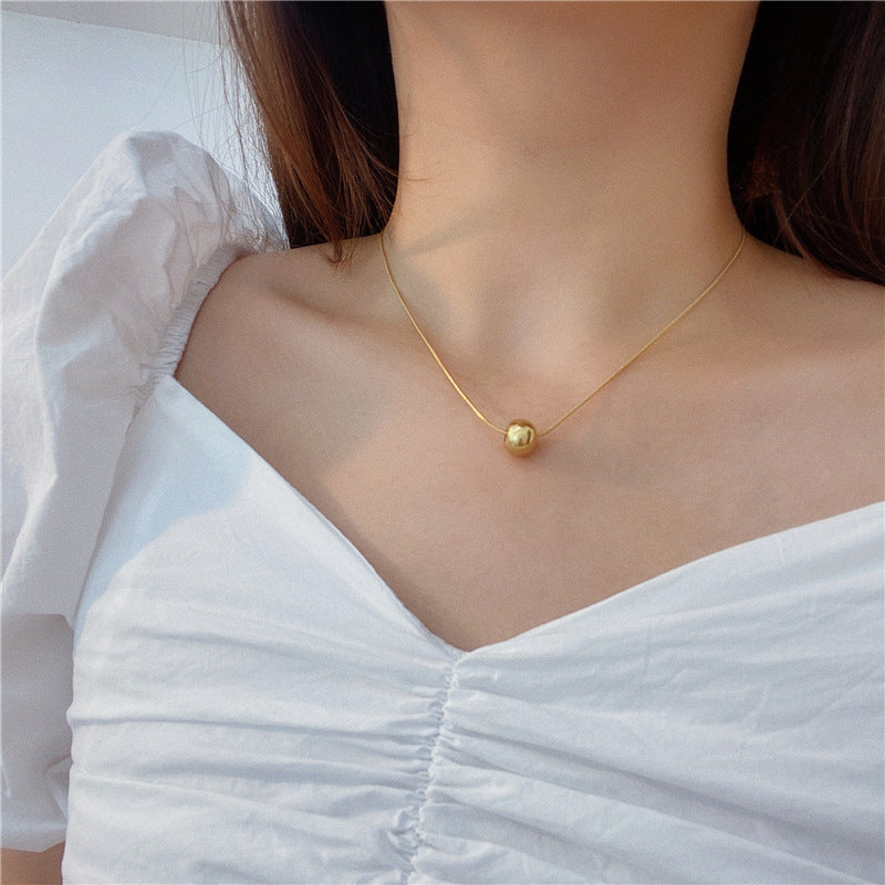 Collana da donna minimalista con pendente a sfera in acciaio al titanio con placcatura in oro e catena a serpente