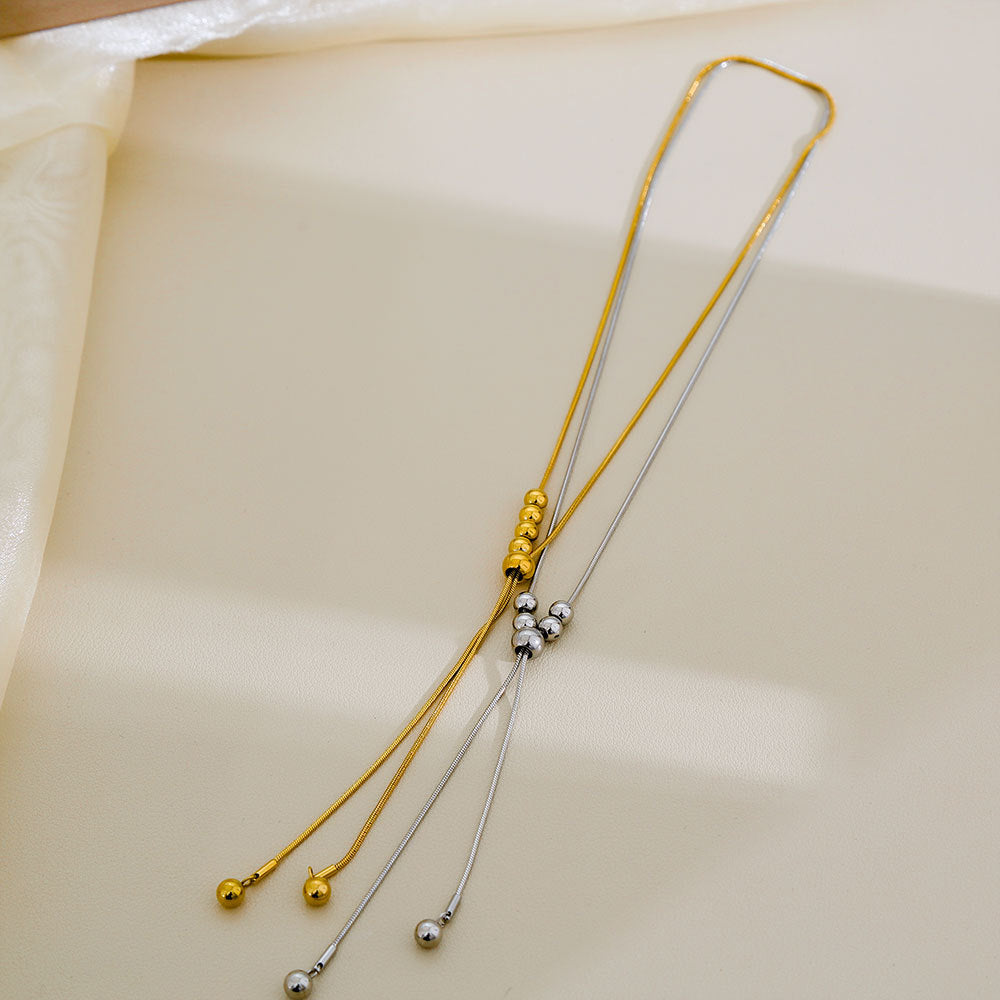 Collana da donna a sfera pendente in acciaio inossidabile dai toni freddi, con dettagli a nappa su catena a serpente regolabile, in stile minimalista