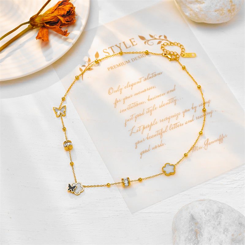 Collana con pendente a farfalla e floreale minimalista di tendenza con accenti di conchiglia bianca e nera, catena a medaglione in acciaio al titanio, finitura placcata per donna