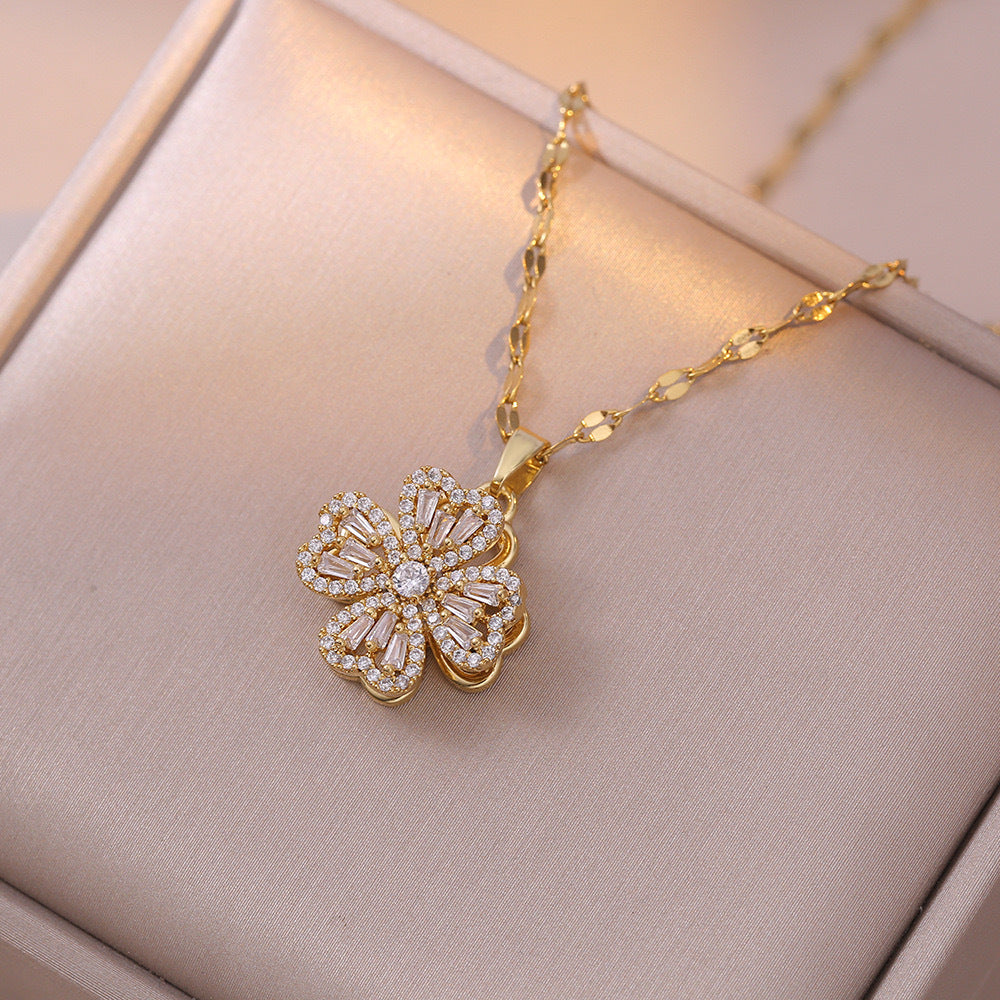 Collana con ciondolo a quadrifoglio rotante da donna in acciaio al titanio con zirconi bianchi micro-incastonati e placcatura in oro su catena ondulata