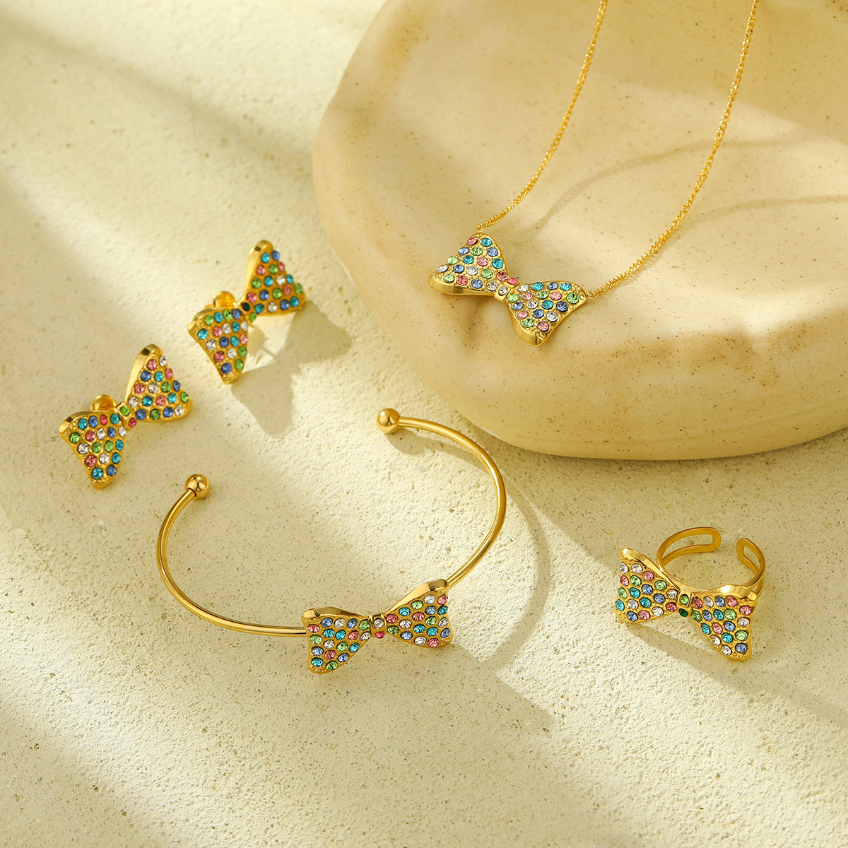 Elegante conjunto de pendientes y collar con forma de lazo de acero de titanio con incrustaciones de pedrería colorida para mujer