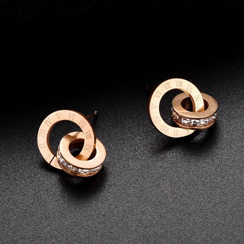Orecchini a perno da donna in acciaio al titanio lucidato con doppio cerchio romano e strass, placcati in color oro e dallo stile fresco e grazioso