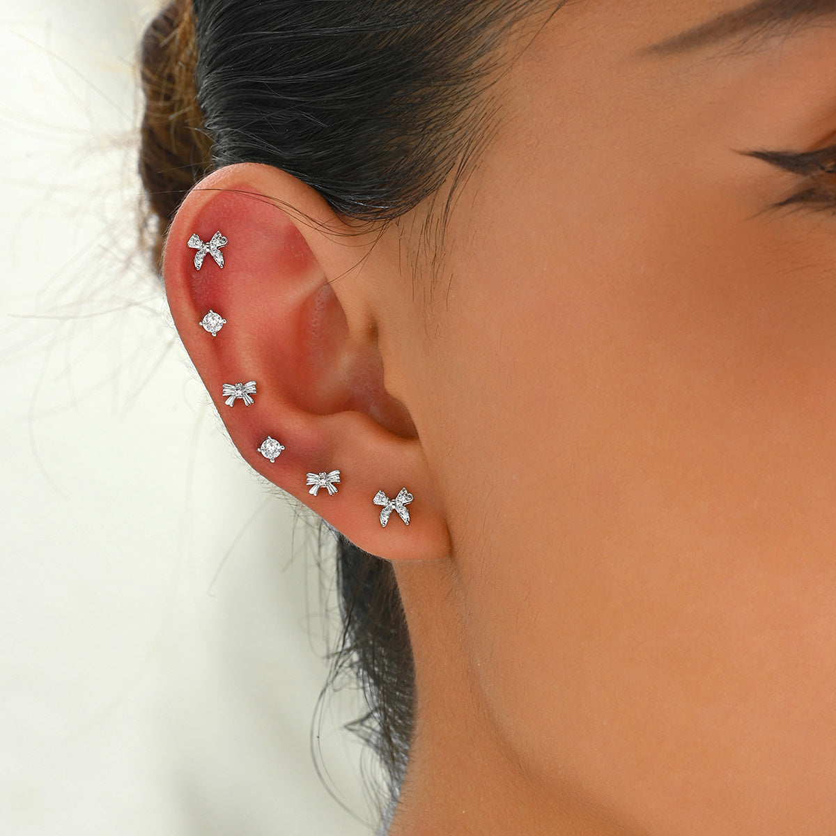 Dulces aretes minimalistas de cobre en forma de moño con incrustaciones de diamantes de imitación para mujer