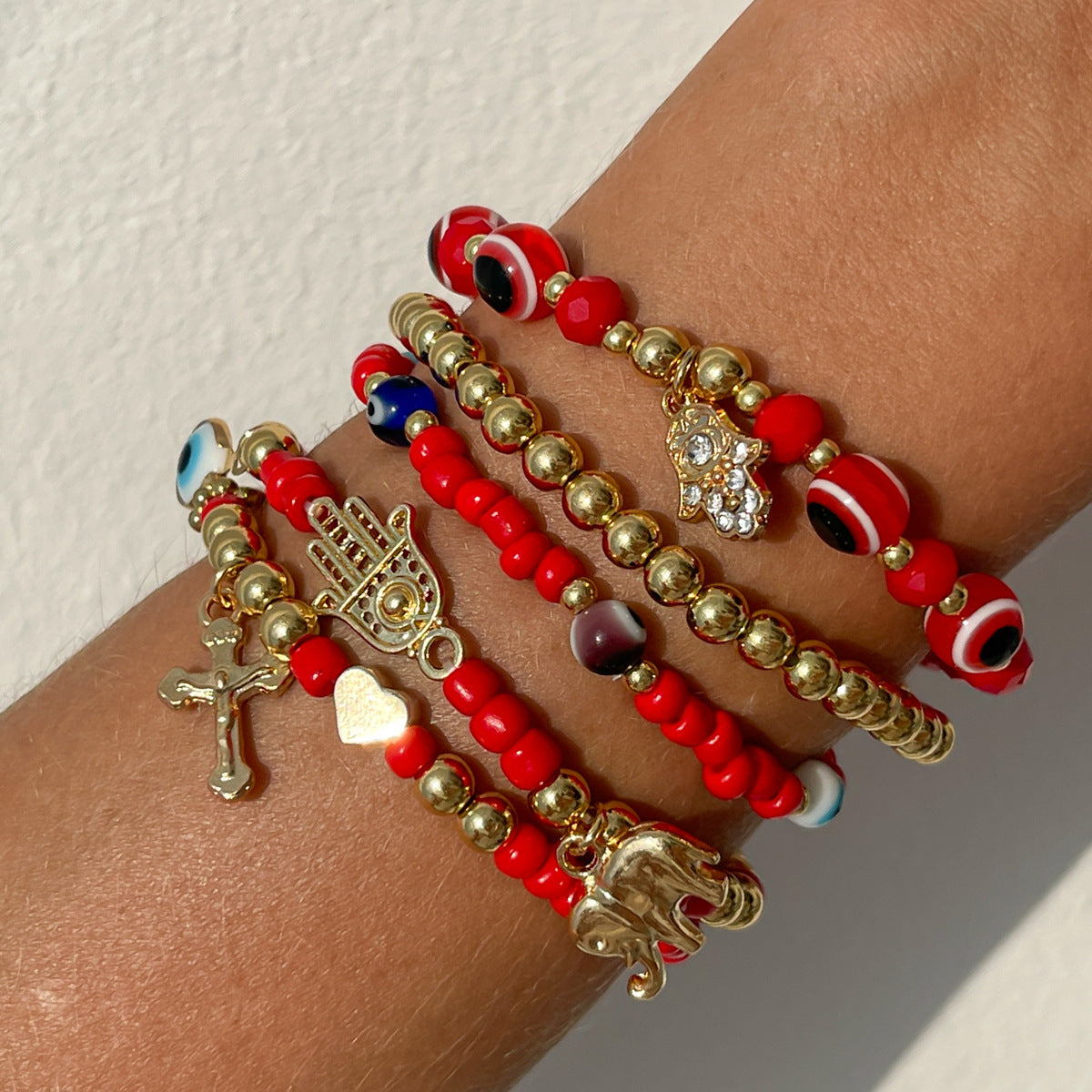 Bracciale in stile bohémien con perline colorate, ciondolo a croce in perla sintetica e nappine decorative