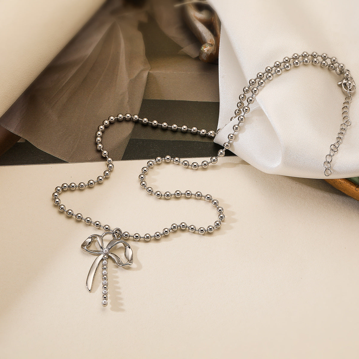 Collana da donna minimalista con fiocco, intarsio di perle e catena placcata oro in rame