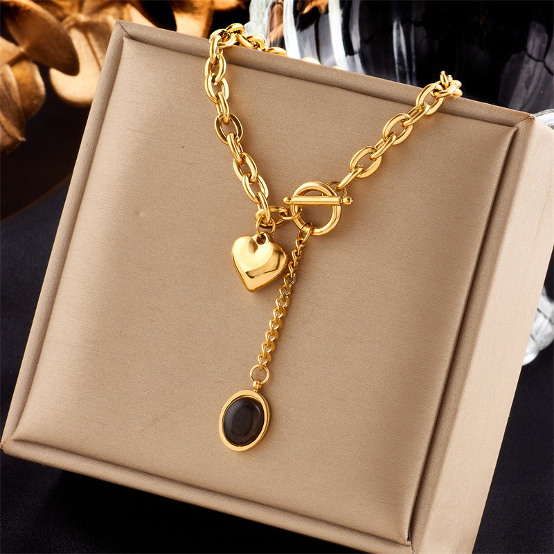Collana con ciondolo ovale minimalista in acciaio titanio con dettaglio nappa e chiusura OT a forma di cuore