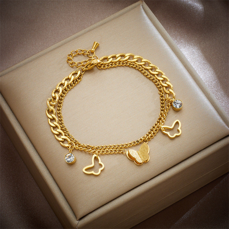 Bracciale con ciondolo a farfalla d'ispirazione vintage in acciaio al titanio con intarsi in strass e dettagli traforati