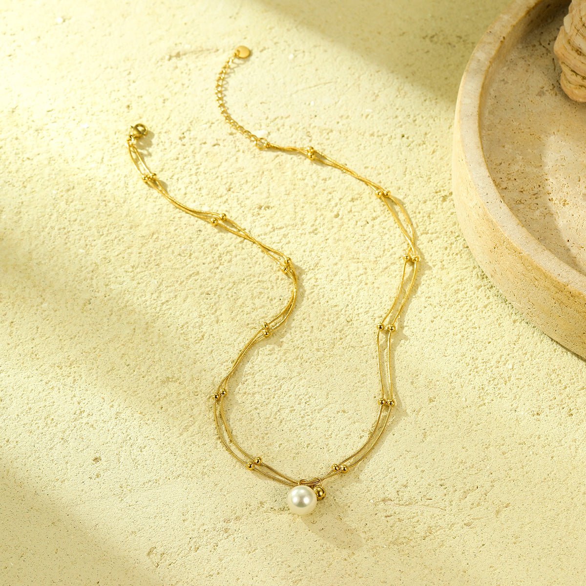 Collana minimalista con perle, doppia catena in acciaio al titanio e design con clavicola placcata in oro 18 carati