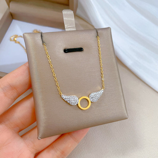 Collana pendente con ali geometriche in stile cartone animato da donna in acciaio al titanio con placcatura in oro e intarsio di strass