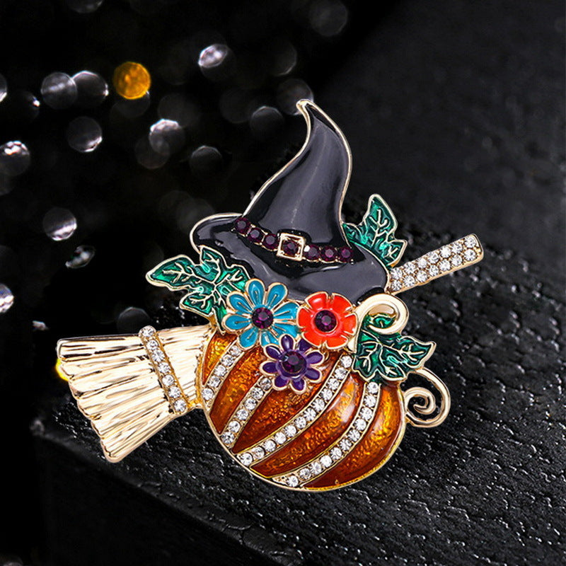 Broche con temática de Halloween, diseño de calabaza con sombrero de bruja y escoba en aleación de zinc con acabado esmaltado y detalles de diamantes de imitación