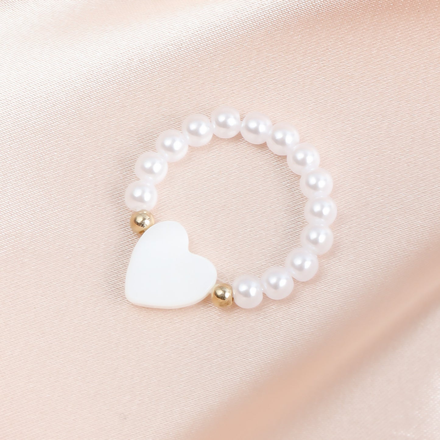Anillo dulce y atrevido de perlas elásticas pequeñas con dije de corazón de nácar en metal chapado para mujer