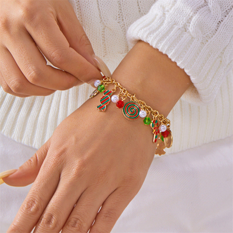 Bracciale artigianale in lega a tema natalizio con ciondolo a forma di Babbo Natale e albero di Natale, perline color caramella, accenti di perle e motivi a fiocco di neve festivi