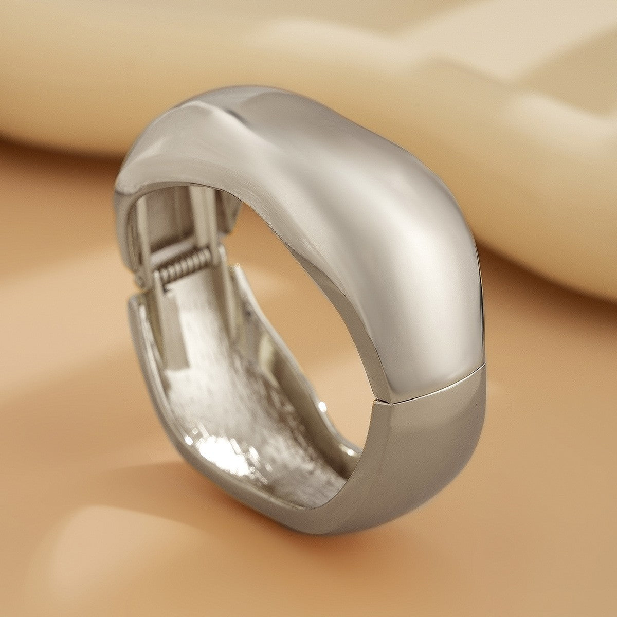Bracciale rigido da donna in metallo audace con design geometrico, superficie lucida e finitura placcata