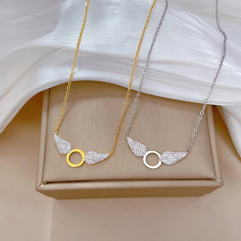 Collana pendente con ali geometriche in stile cartone animato da donna in acciaio al titanio con placcatura in oro e intarsio di strass