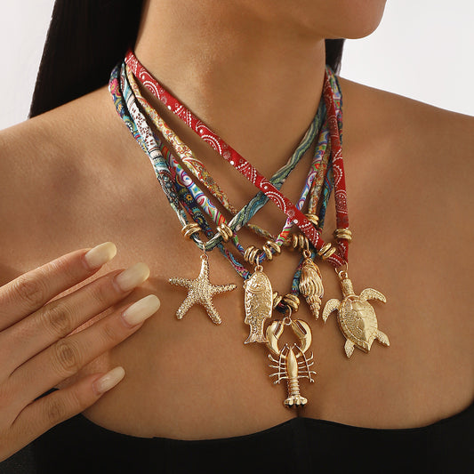 Collar colgante de aleación con temática marina, dulce y atrevido, con motivos de tortugas, conchas marinas y estrellas de mar, y detalles de tela para mujer