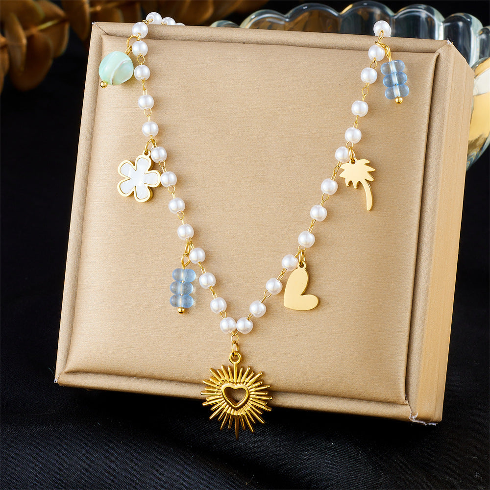 Collana pendente minimalista a forma di cuore in acciaio inossidabile con catena di perle e dettagli floreali e palma da cocco