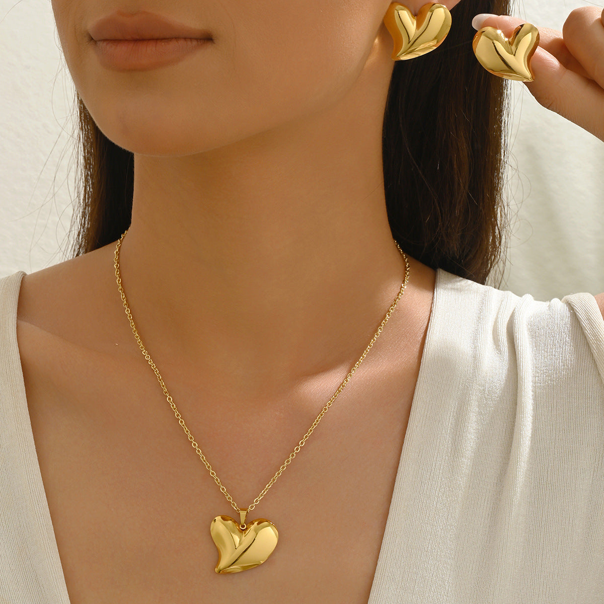 Collana con pendente a cuore geometrico minimalista e orecchini coordinati in lega con finitura galvanica da donna