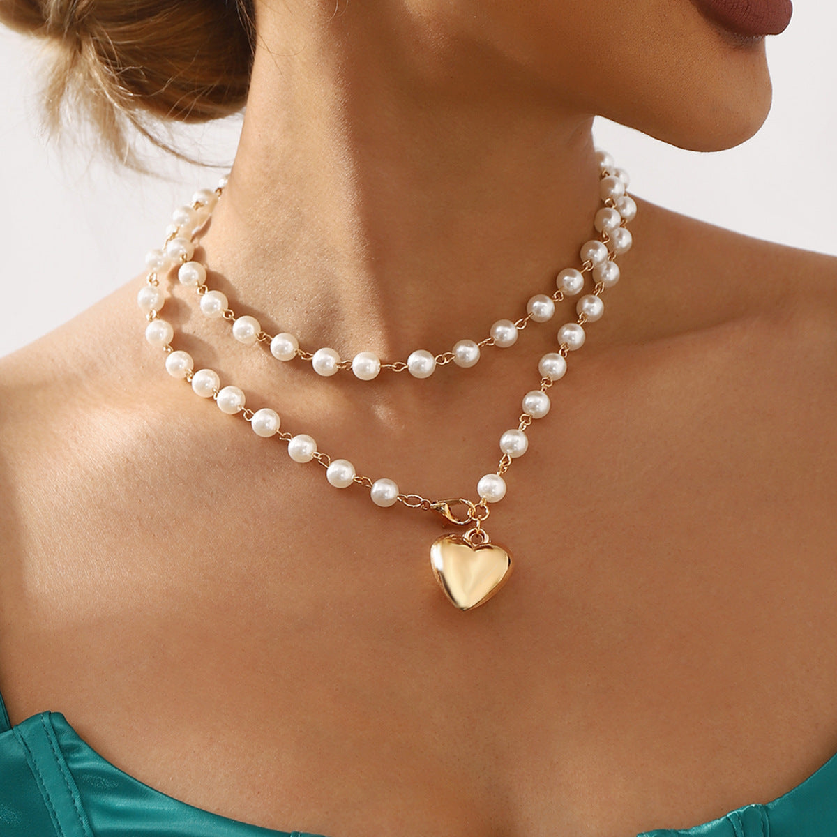 Collar de doble capa minimalista con colgante de corazón, acentos de perlas simuladas y acabado chapado en oro para mujer
