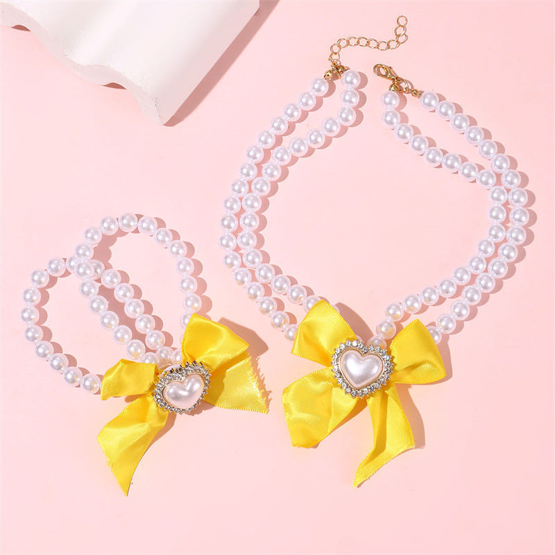 Elegante collar de perlas de doble capa para niñas con lazo y colgante de corazón en estilo estético crema, joyería de resina