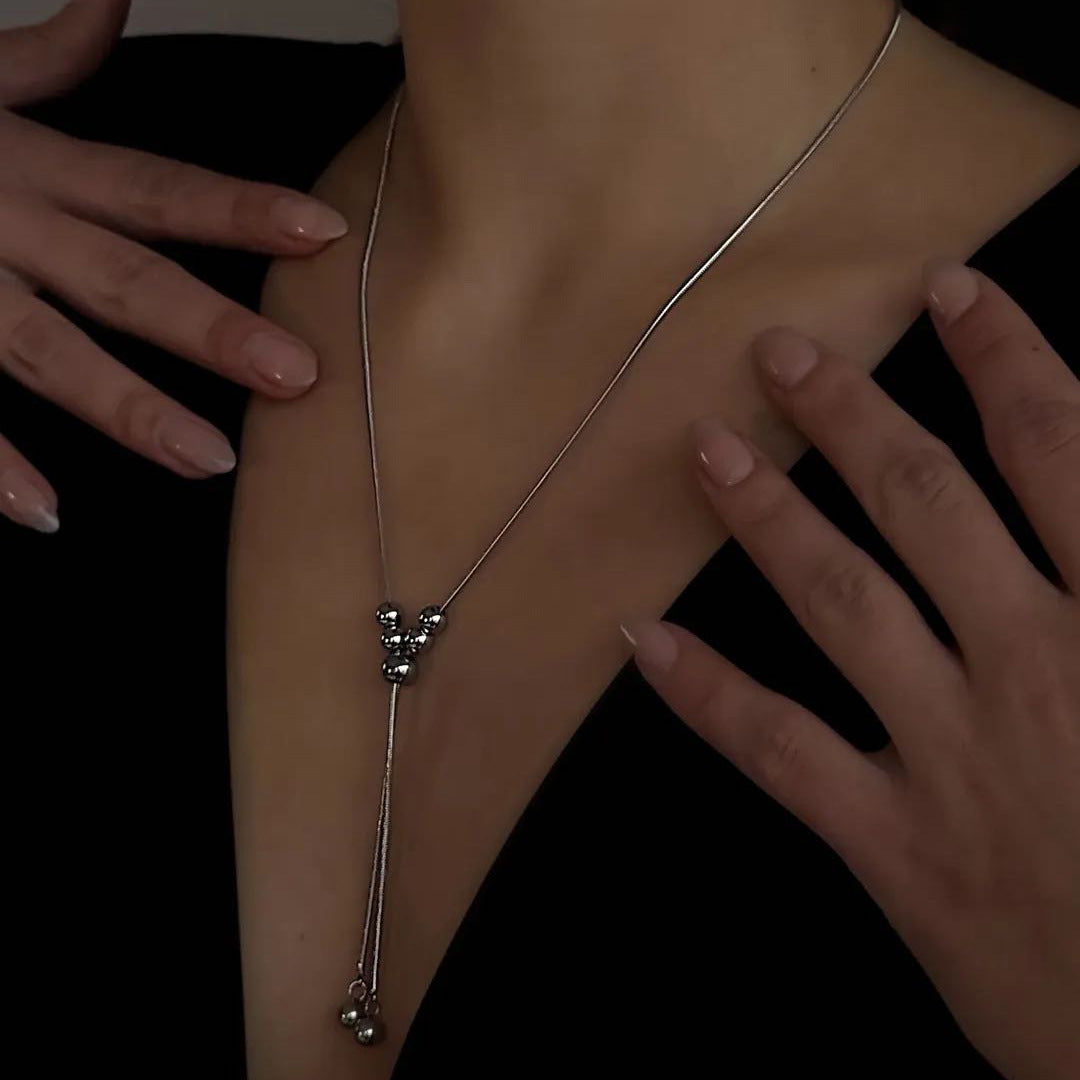 Collana da donna a sfera pendente in acciaio inossidabile dai toni freddi, con dettagli a nappa su catena a serpente regolabile, in stile minimalista