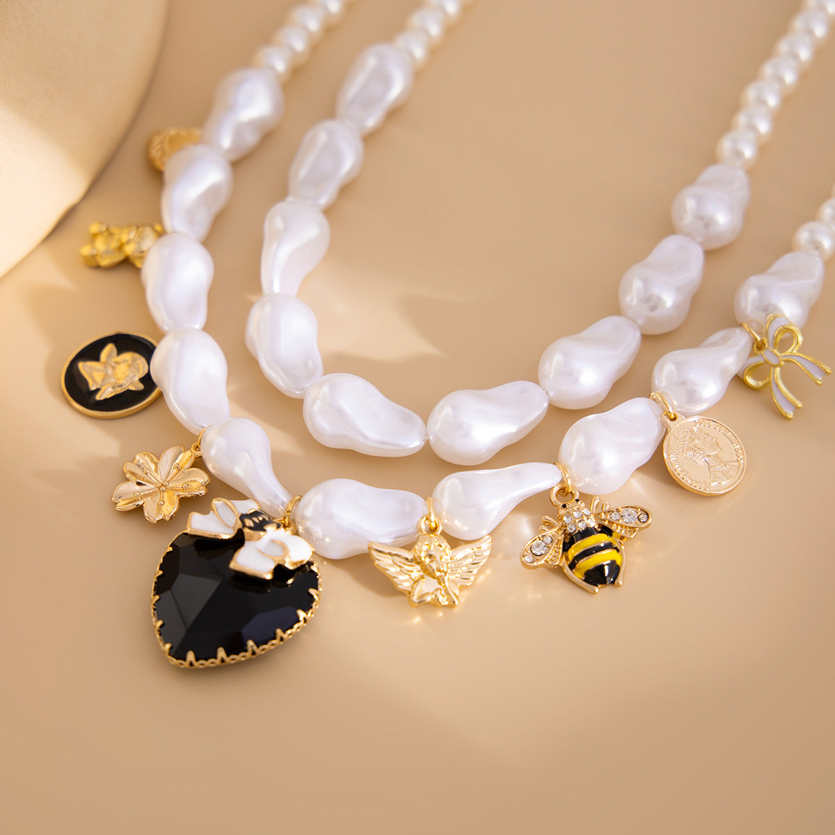 Collana con pendente a forma di ape esagerata a cuore e forma geometrica con base in lega placcata, perle imitate e intarsi in strass acrilici per donna
