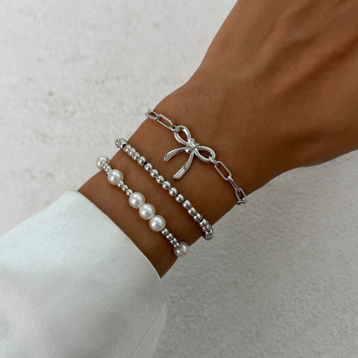 Minimalist Bow Knot and Star-Shaped Pendant Bracelet for Women with Plated Metal and Imitation Pearl Accents