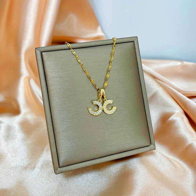 Collana con ciondolo girevole a quadrifoglio in acciaio al titanio con zirconi micropavé da donna