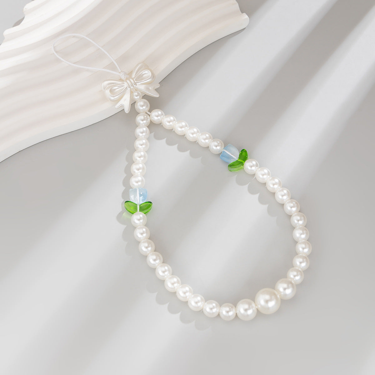 Bonita correa de teléfono con nudo de lazo de tulipán y perlas de imitación para mujeres, accesorio tejido a mano con dulce estilo floral