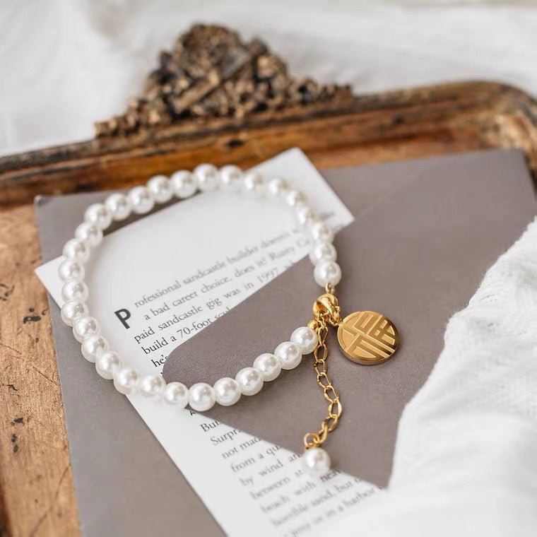Bracciale minimalista geometrico in acciaio al titanio con pendente a carattere "Fu" placcato oro 18K e nappe di perle